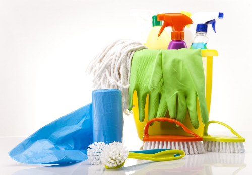 Cleaner using safe lifting and handling techniques during work